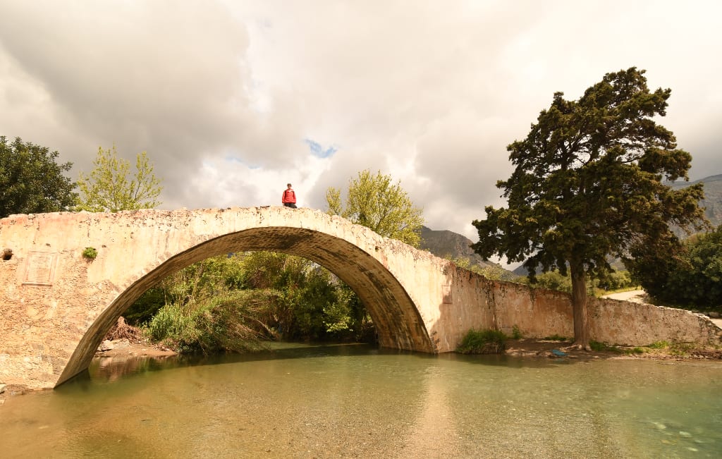 Frau steht auf antiker Brücke auf Kreta