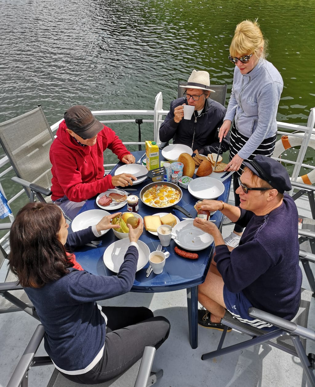 Menschen frühstücken auf Deck eines Bootes