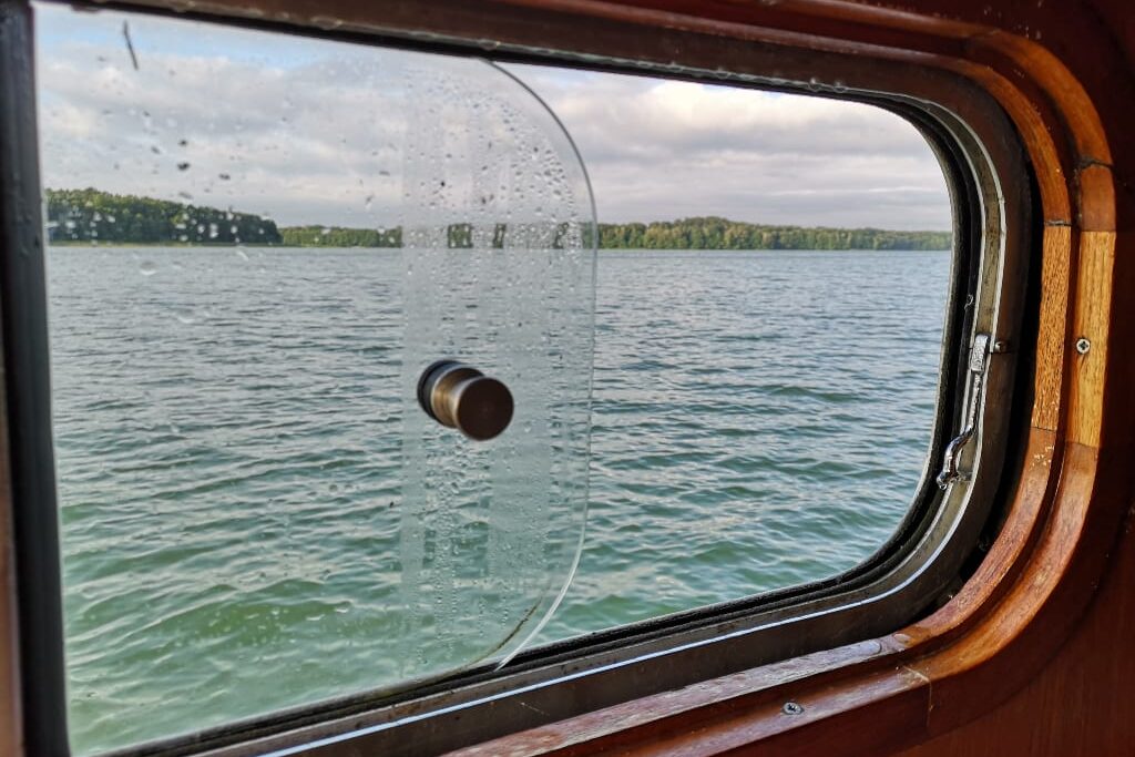 Fenster eines Schiffs mit Seeblick