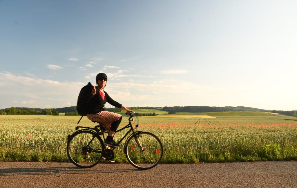 Radfahrerin mit gestrecktem Daumen auf einem Rad