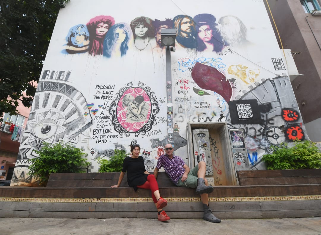 Paar sitzt vor Street Art mit Jim Morrison