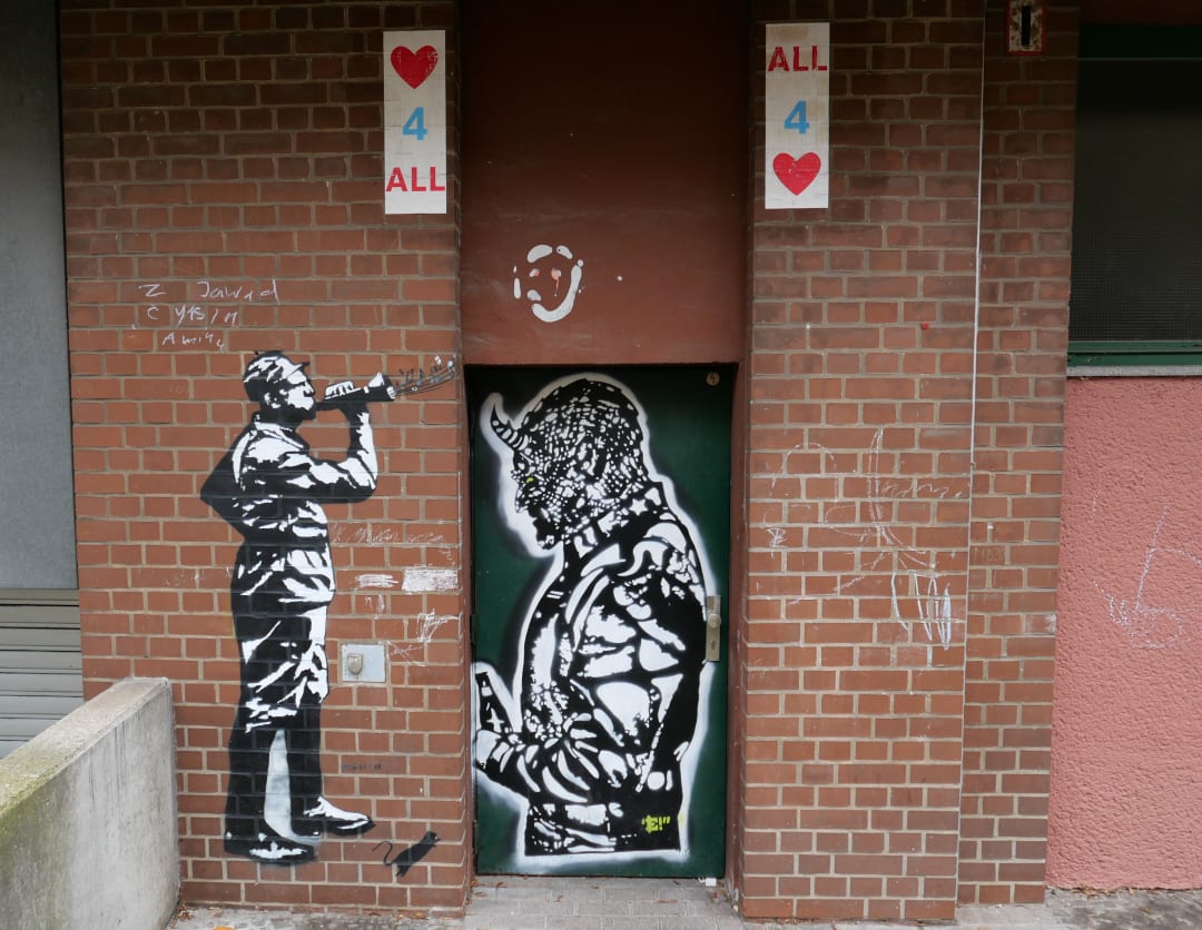 Schwarz-weiße Stencils an Backsteinmauer