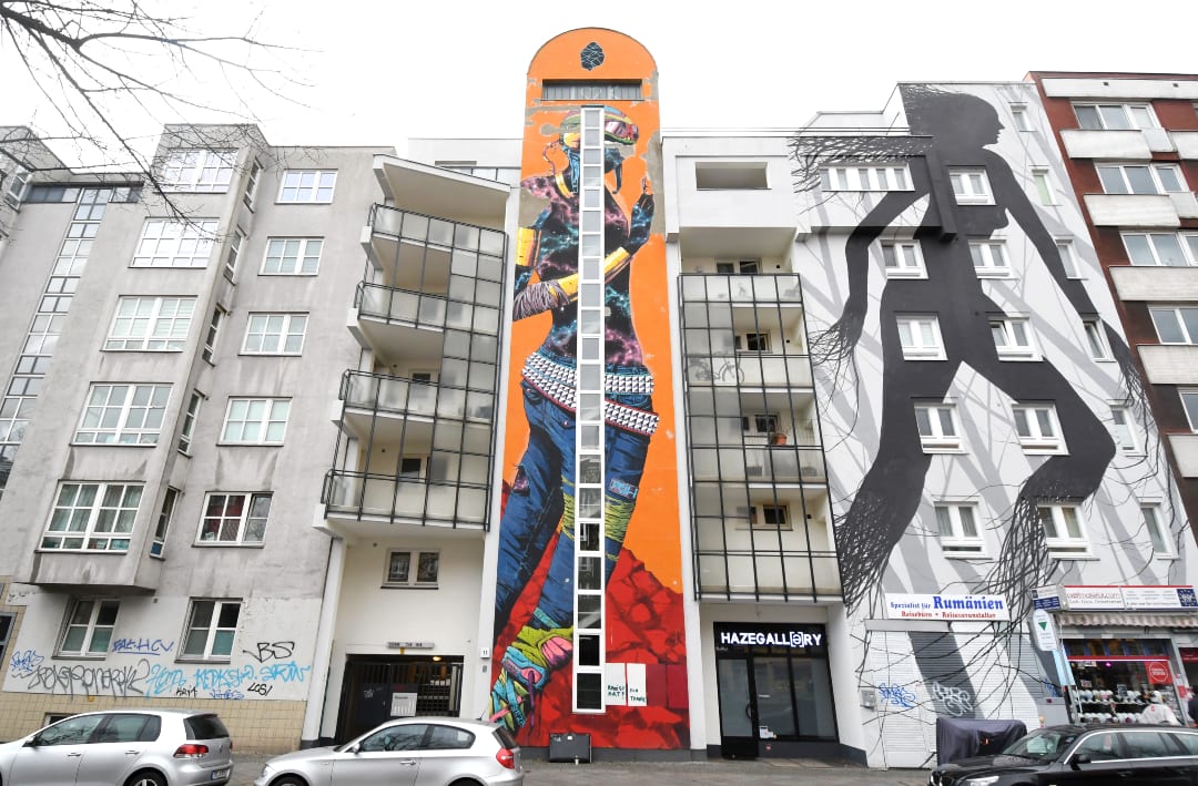 Zwei lange schmale Murals an Häuserwand