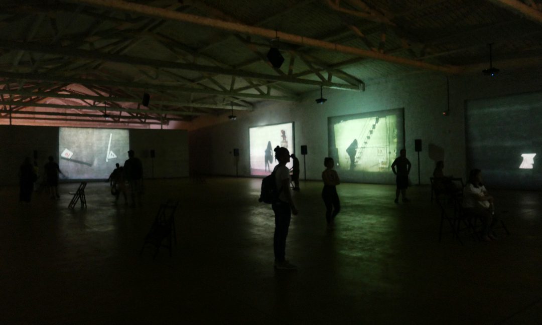 Dunkle Ausstellungshalle mit Projektionen