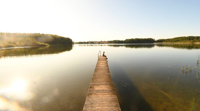 Brandenburgs schöner Nordosten: Warum man mal in die Uckermark fahren sollte Frau sitzt auf Steg eines Sees