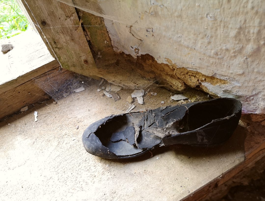 Kaputter Schuh mit Spinnweben Bügellohe