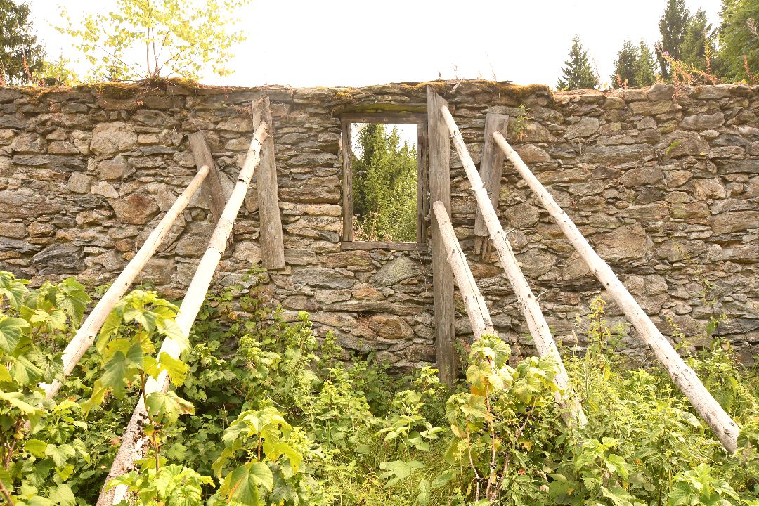 Von Balken gestützte Ziegelsteinmauer in Bügellohe