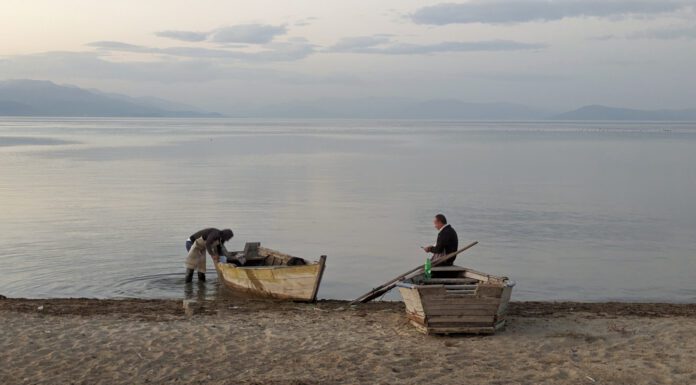 Roadtrip Ohridsee: Mit dem Van um den zweitgrößten See des Balkans Zwei Männer auf ihren Booten am Strand eines Sees