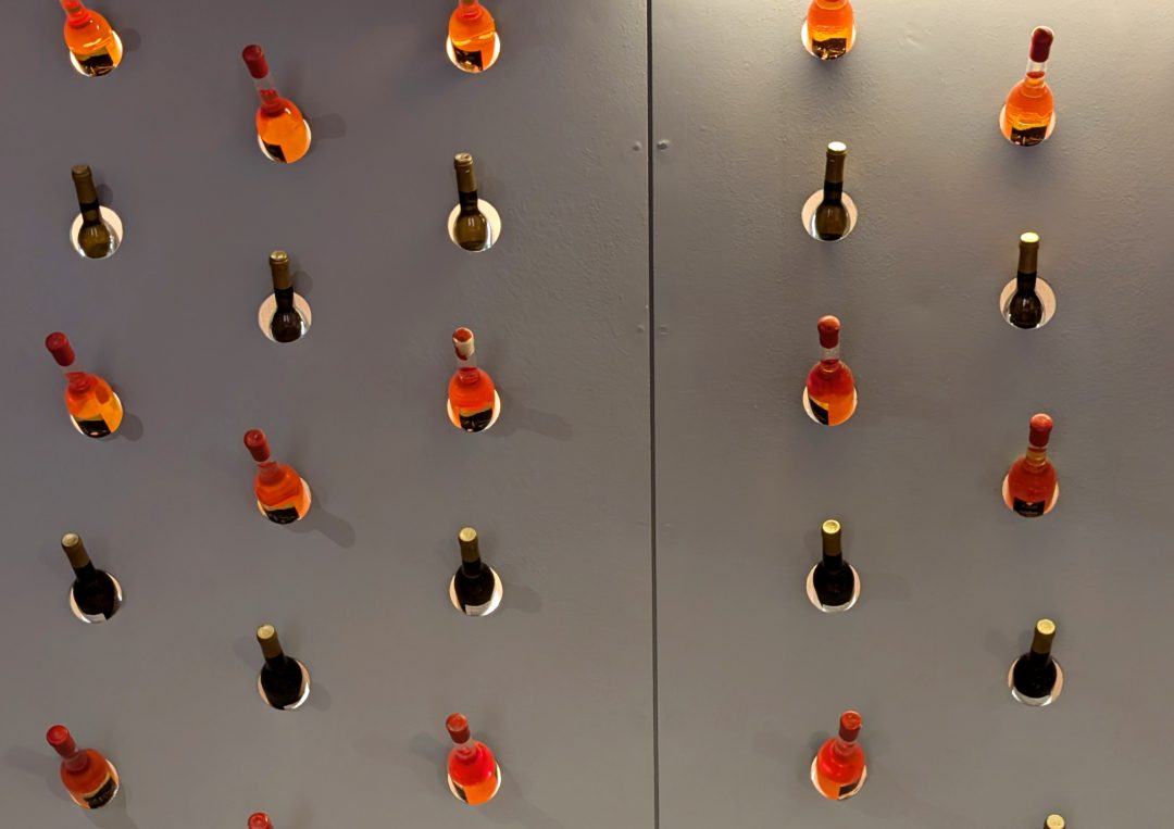 Graue Wand mit Weinflaschen