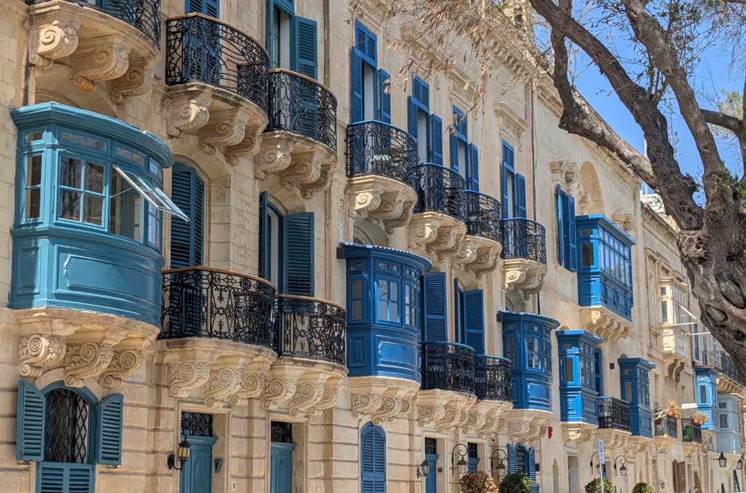 Sandsteinfarbenes Stadthaus mit blauen Erkern