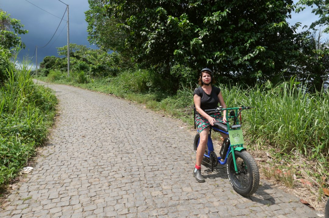 Frau auf E-Bike in tropicher Landschaft